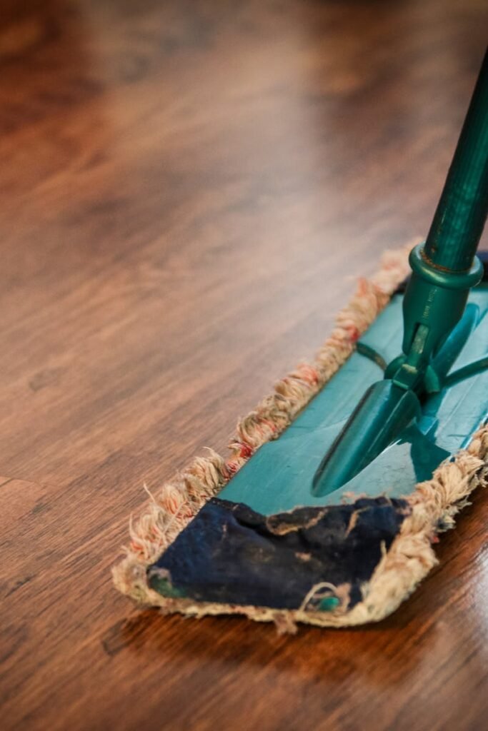 cleaning-washing-cleanup-the-ilo-48889-48889 A detailed view of a mop cleaning a wooden floor, showing texture and pattern.